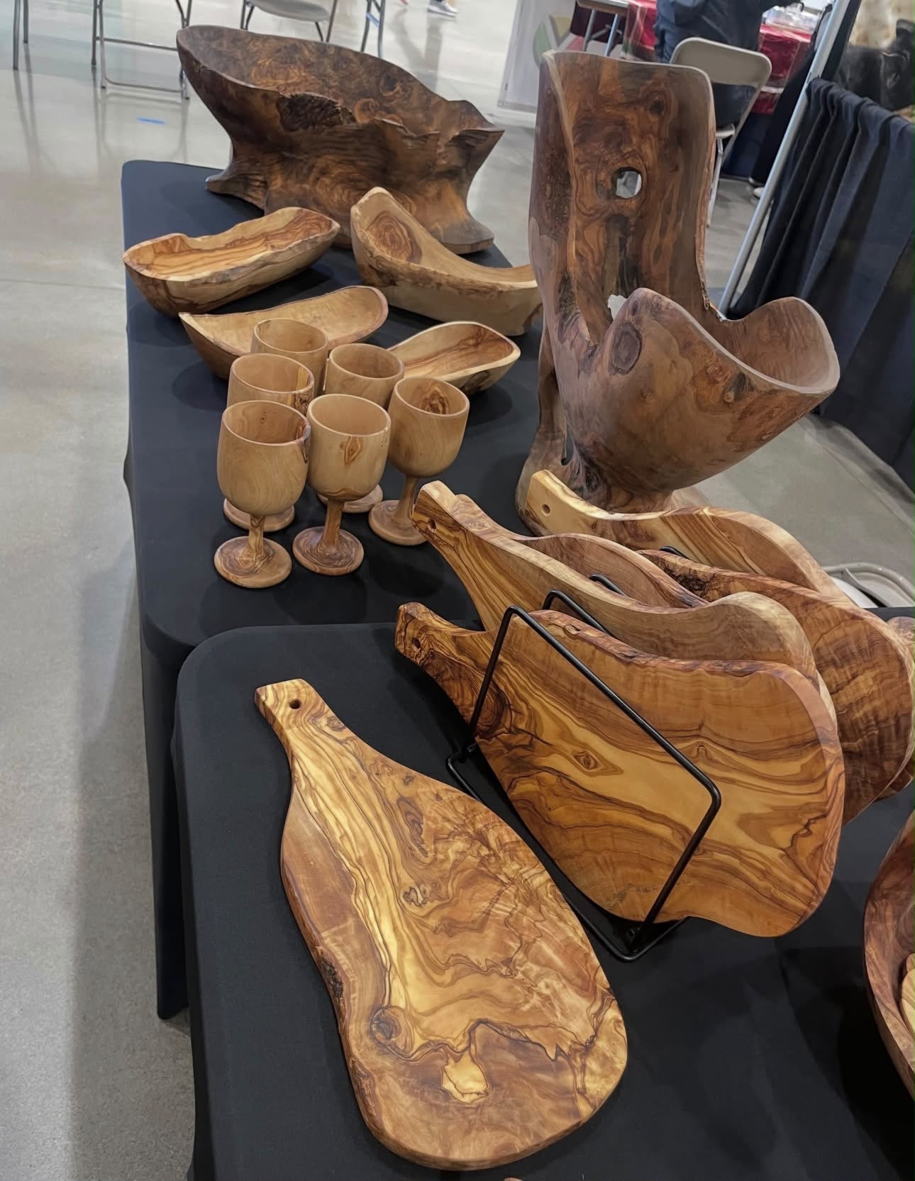 Olive wood goblets, serving boards and large sculptural bowls on a table