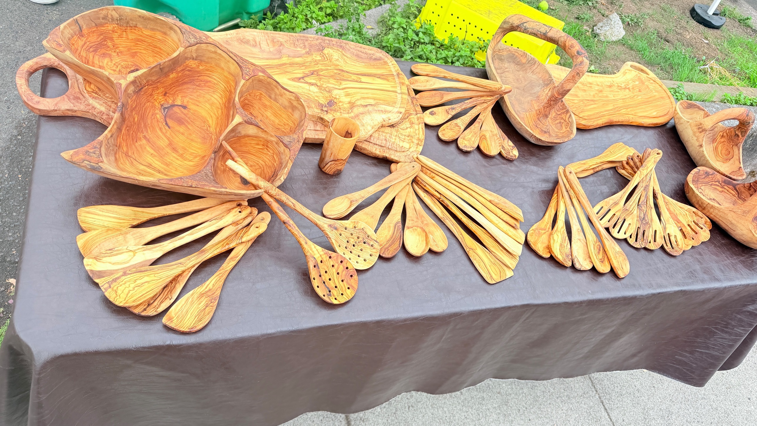 A table of hand carved olive wood spoons, serving boards and bowls at a market